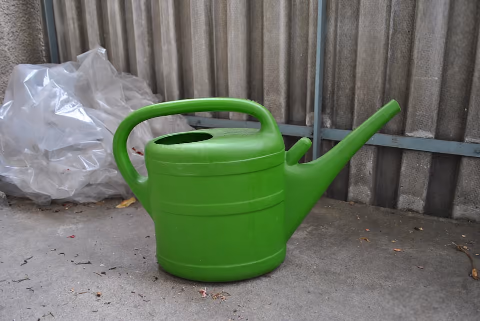 Arrosoir vert en plastique posé au jardin Arrosoir vert en plastique posé au jardin.