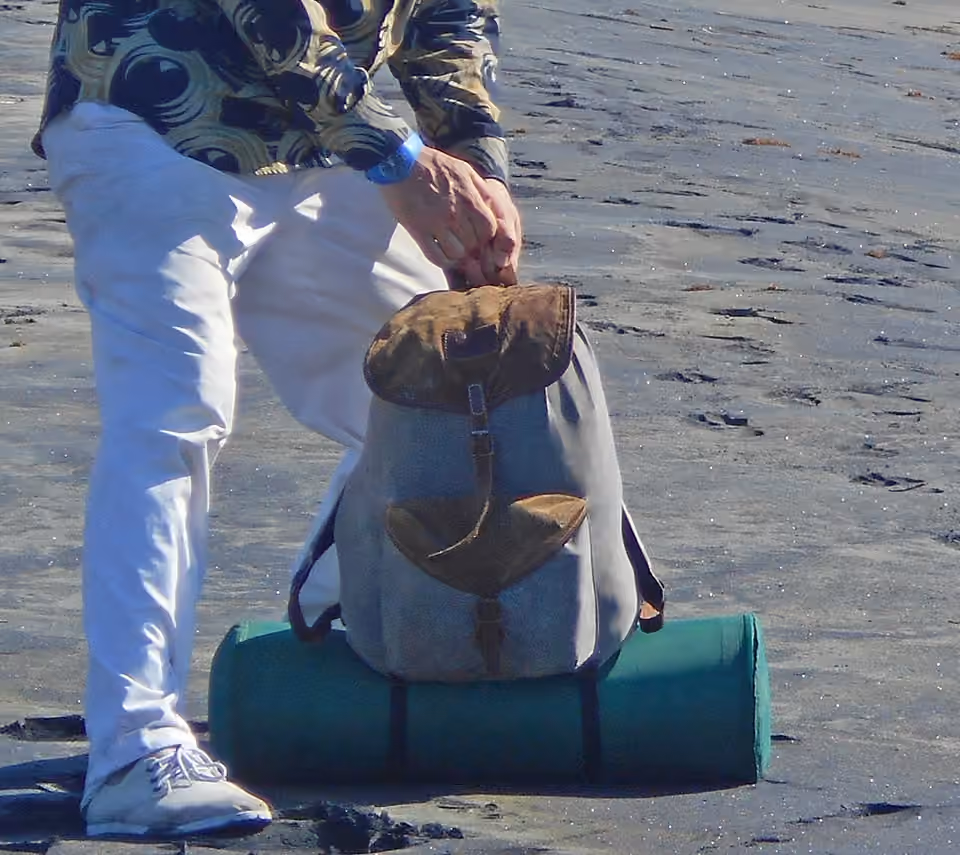 Sac à dos chargé, avec un tapis de sol fixé à l’extérieur Un sac à dos chargé, avec un tapis de sol fixé à l’extérieur.