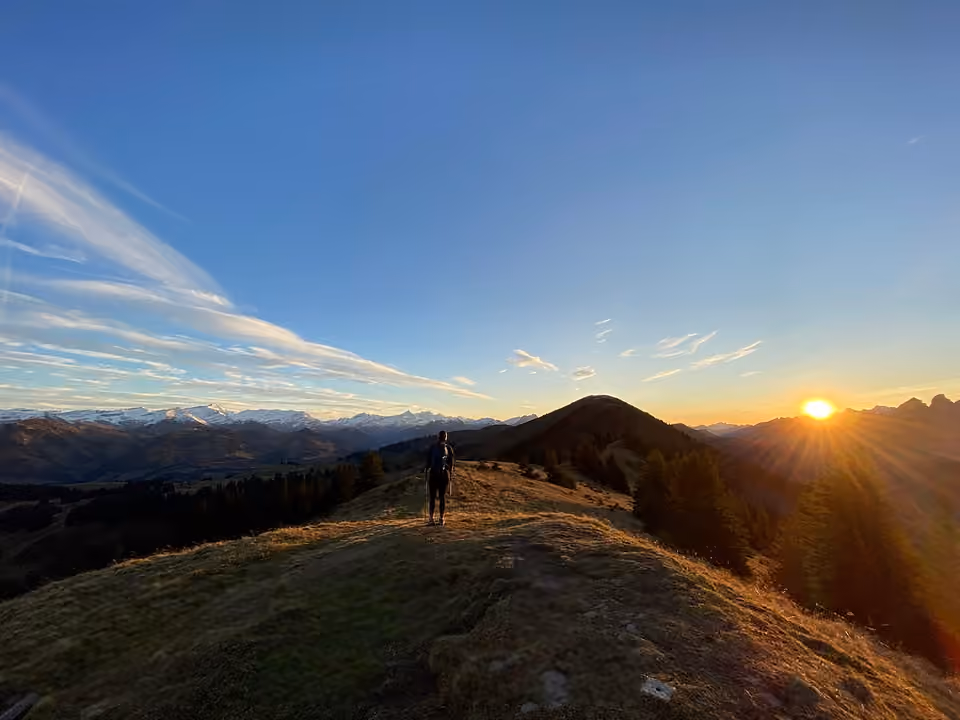 Randonneur progresse sur une crête alors que le soleil se couche, près du col de Jaun en Suisse Un randonneur progresse sur une crête alors que le soleil se couche, près du col de Jaun en Suisse.
