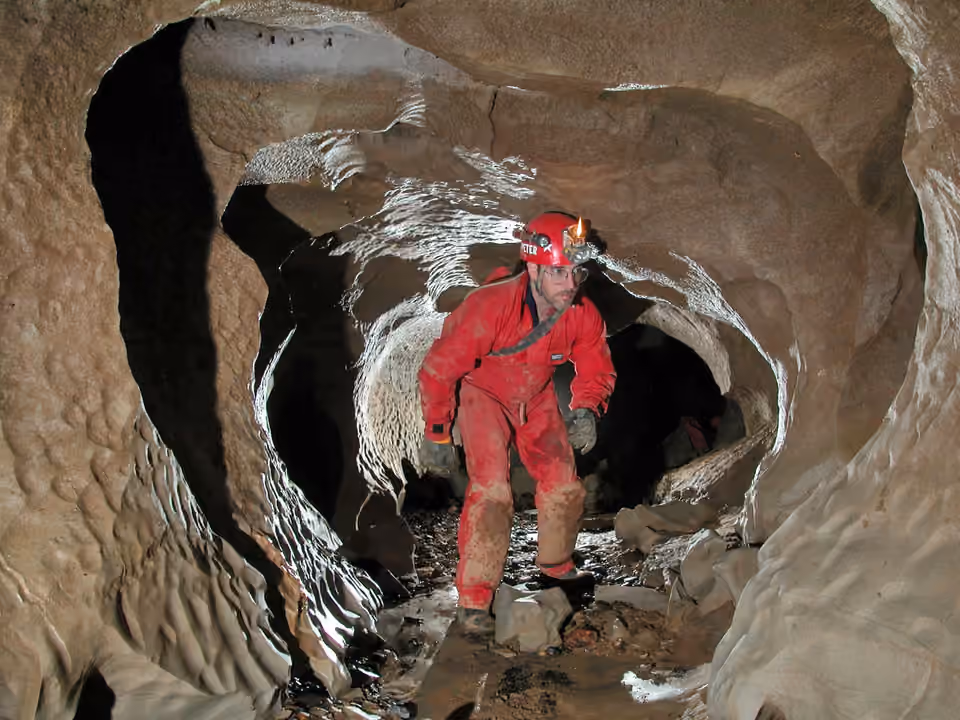Spéléologue équipé d’un casque et d’un éclairage dans une grotte de l’Alabama Spéléologue équipé d’un casque et d’un éclairage dans une grotte de l’Alabama.